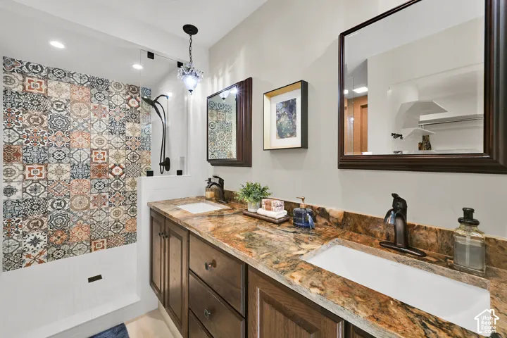 Double vanity with stone countertop, dark wood-finish cabinetry, and oil-rubbed bronze fixtures