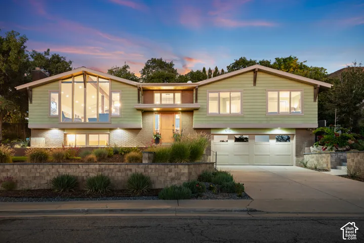 Oak Hills residence remodeled throughout featuring a two-car garage, expansive picture windows, and a multi-level stone retaining walls