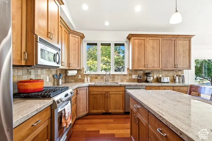 Kitchen featuring warm wood cabinetry, granite countertops, and hardwood flooring