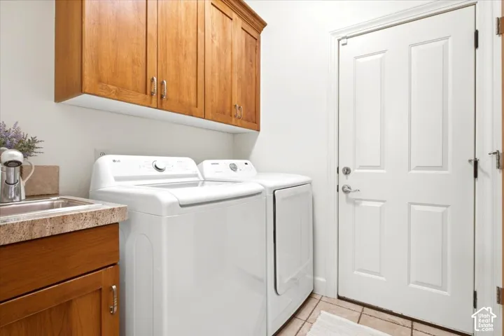 Laundry area featuring wood cabinetry, a built-in sink with a countertop, and extra storage