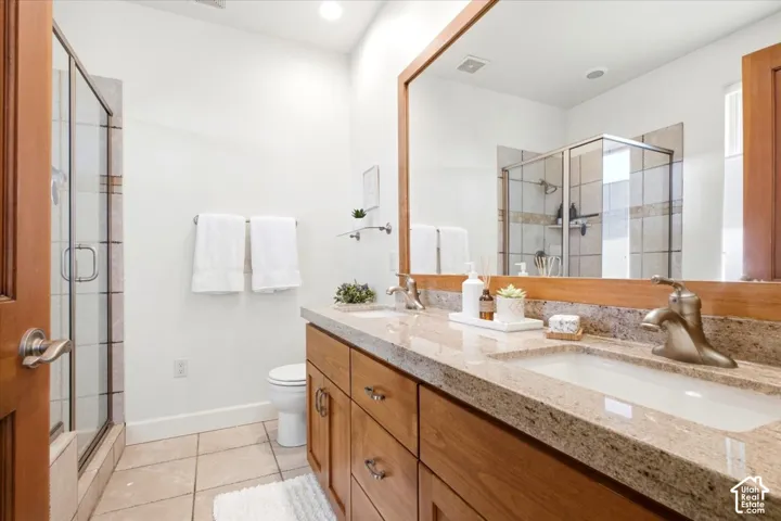 Primary suite bathroom featuring a dual vanity with granite countertops