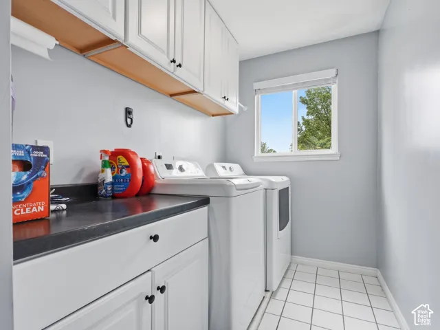 White shaker-style cabinetry with black hardware, dark countertop, and tiled flooring