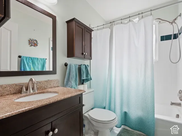 Bathroom featuring a dark wood vanity with a light-colored countertop, an undermount sink, and a framed mirror