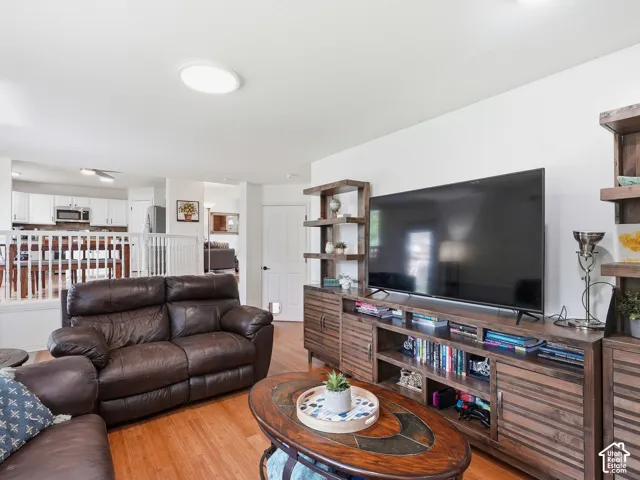 Hardwood flooring, recessed ceiling light, white interior walls, white kitchen cabinetry, and built-in shelving