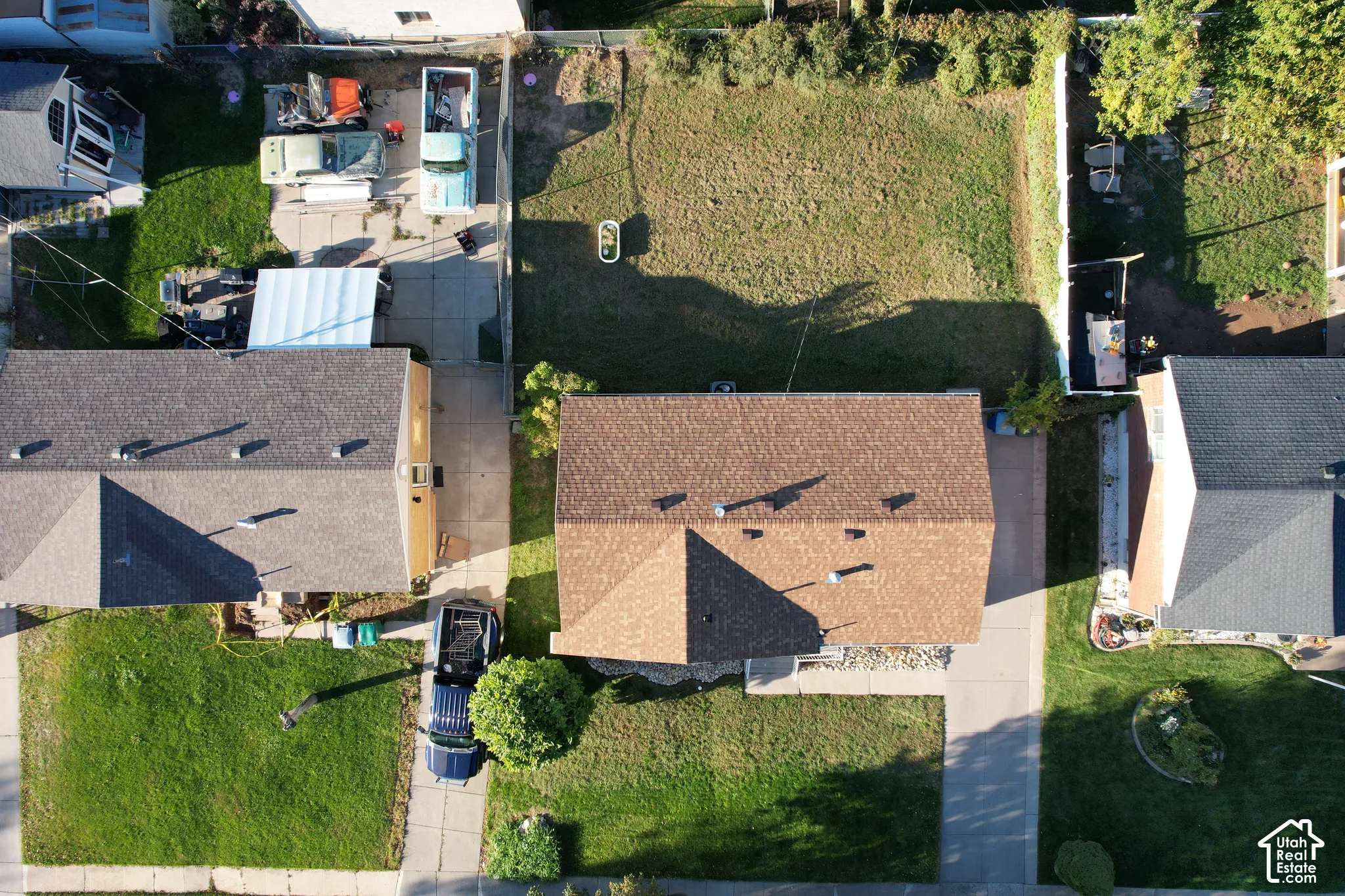 Brown shingle roof, concrete driveway, and grassy yard