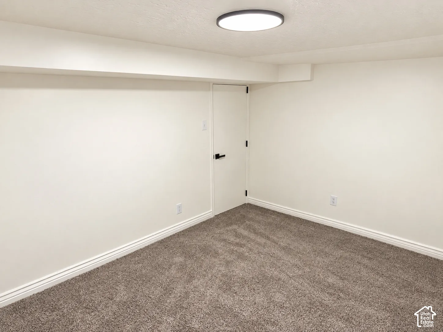 Wall-to-wall carpeting, flush-mount ceiling light, white walls, and white trim