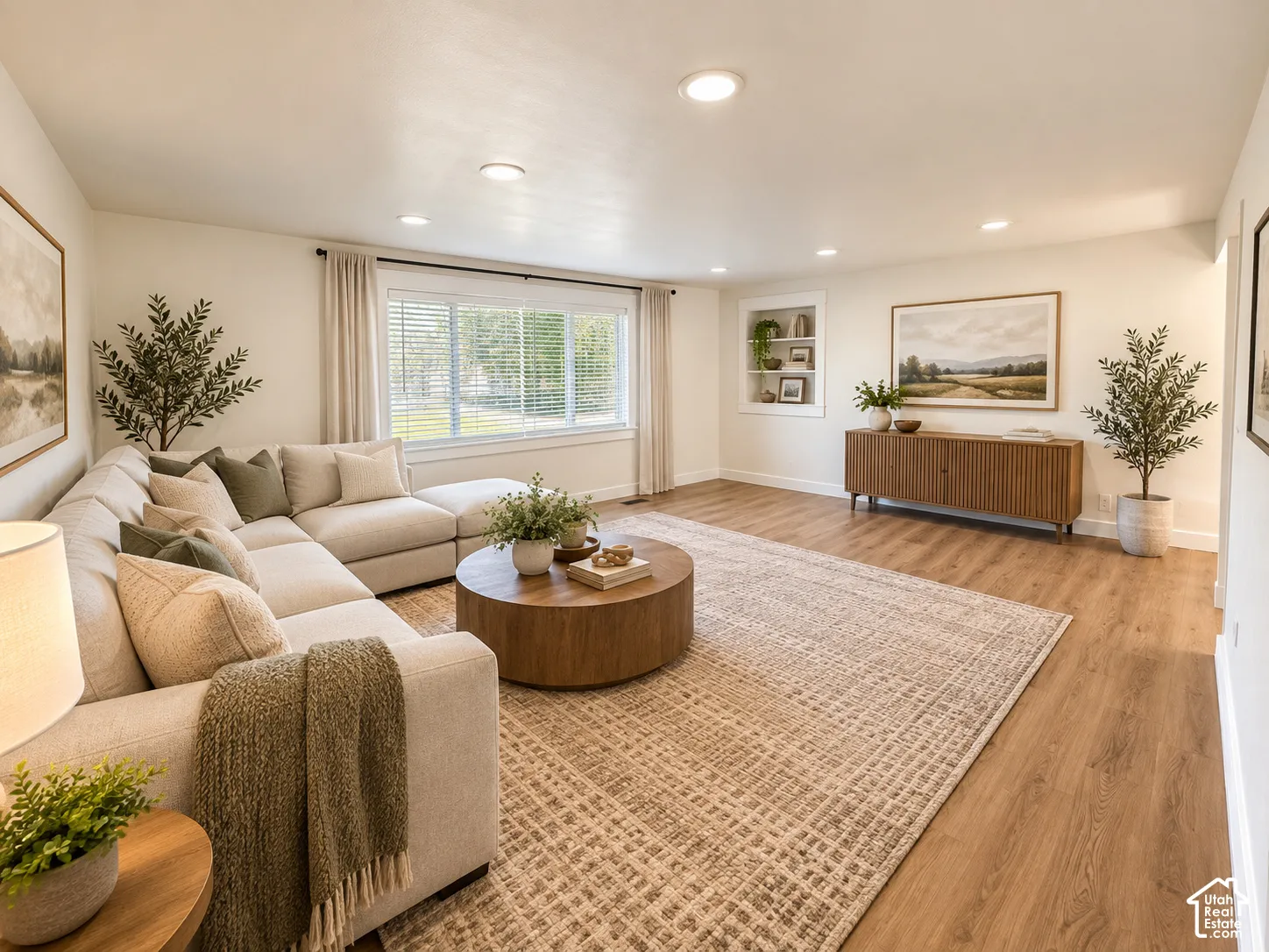 Recessed lighting, wood-finish flooring, built-in shelving, large window with blinds, and white walls