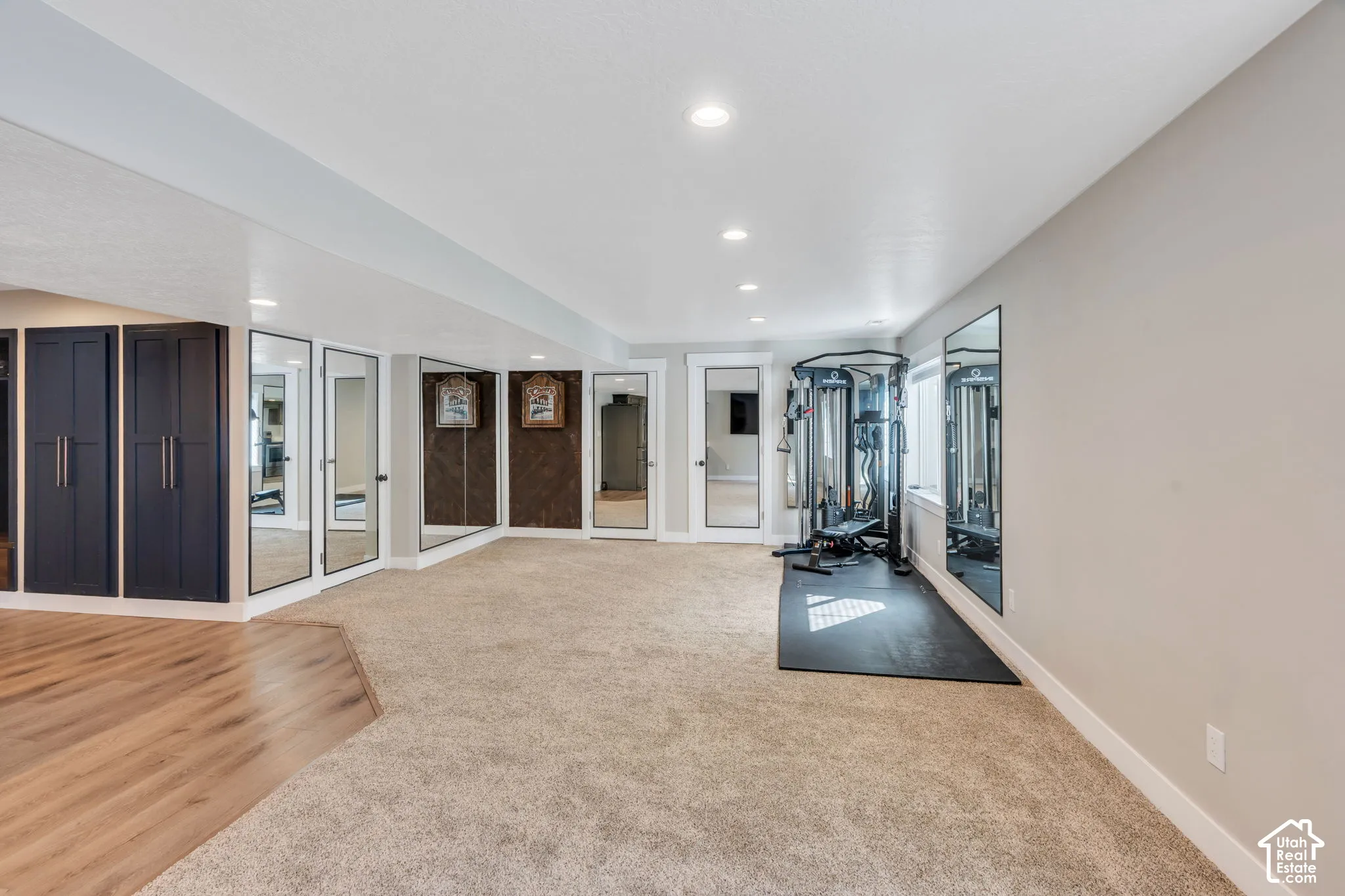Recessed lighting, light gray wall paint, and full-length mirrors