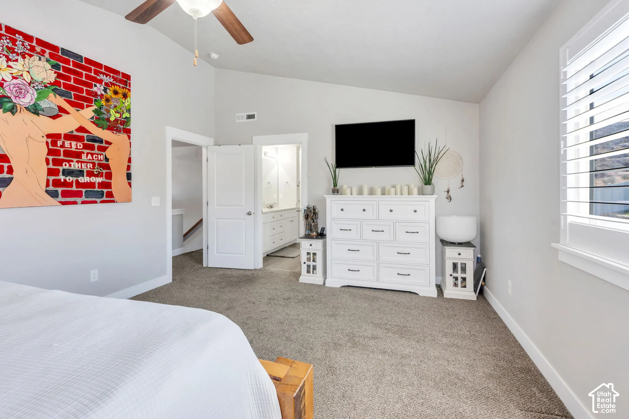 Vaulted ceiling with a ceiling fan, plush carpeting, and white interior doors