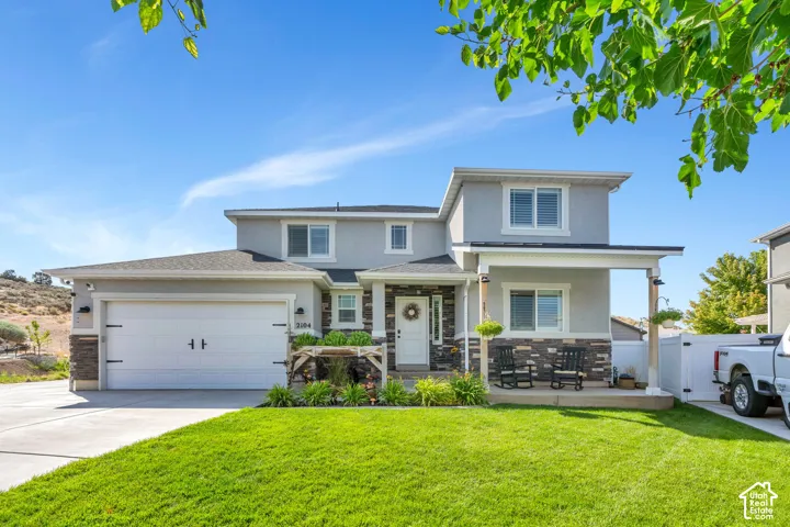 Two-story exterior with a two-car garage, stone veneer accents, and a covered porch