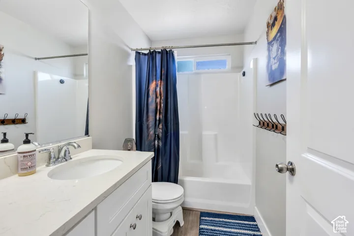 White vanity with a light-toned countertop, under-mount sink, and chrome faucet