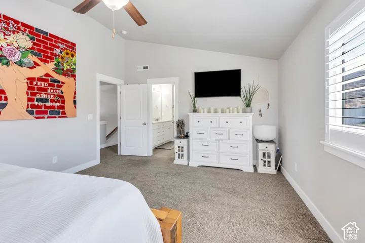 Vaulted ceiling with a ceiling fan, plush carpeting, and white interior doors