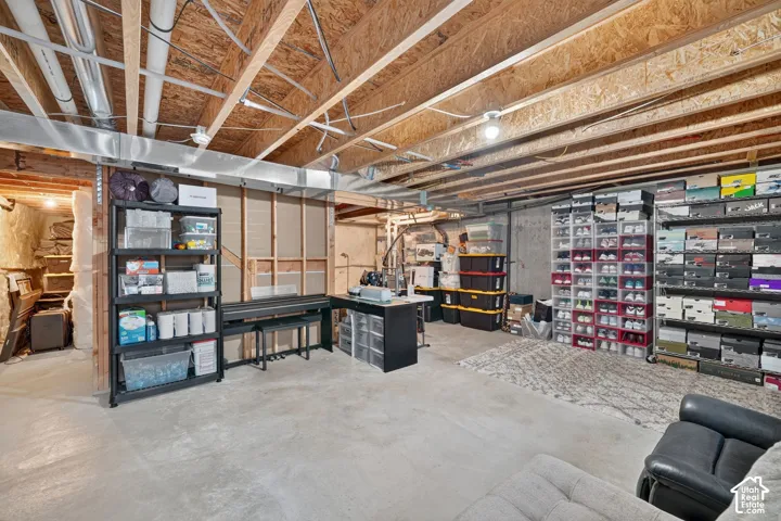 Unfinished basement with exposed ceiling joists and concrete flooring