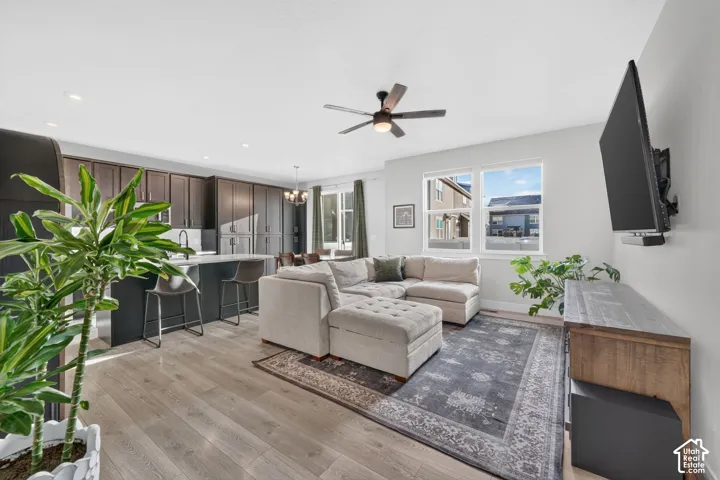 Open-concept living space featuring wood-finish flooring, recessed lighting, and a ceiling fan