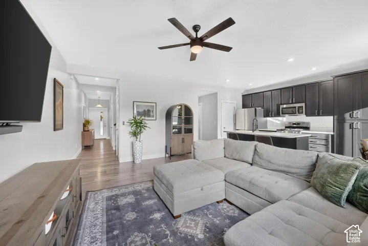 Open-concept living area with wood-finish flooring, recessed lighting, and a ceiling fan