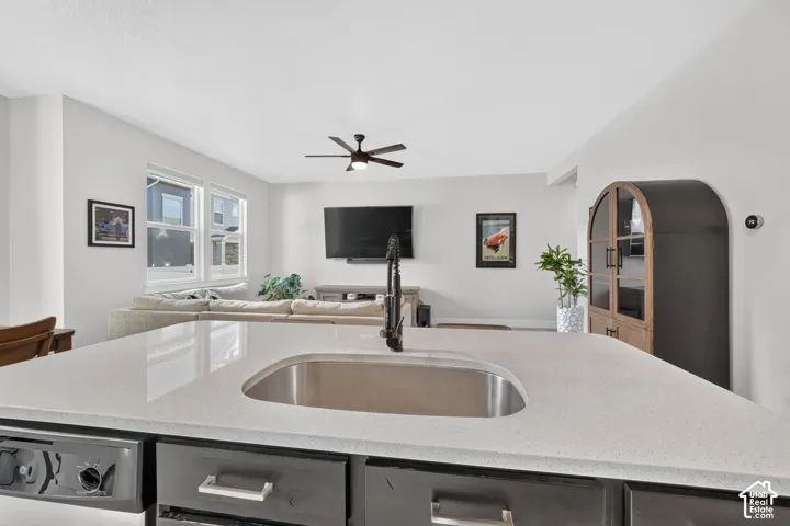 Kitchen island with an undermount sink, a gooseneck faucet, and quartz countertops