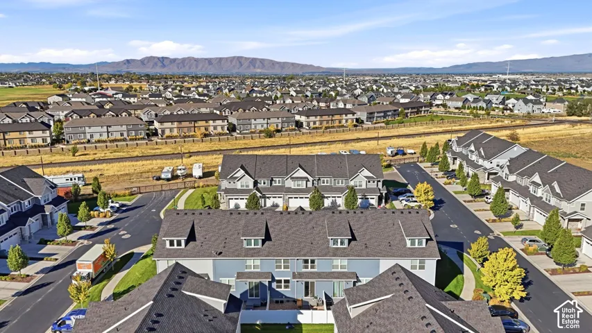 Residential community featuring townhomes with attached garages, paved streets, and landscaped common areas