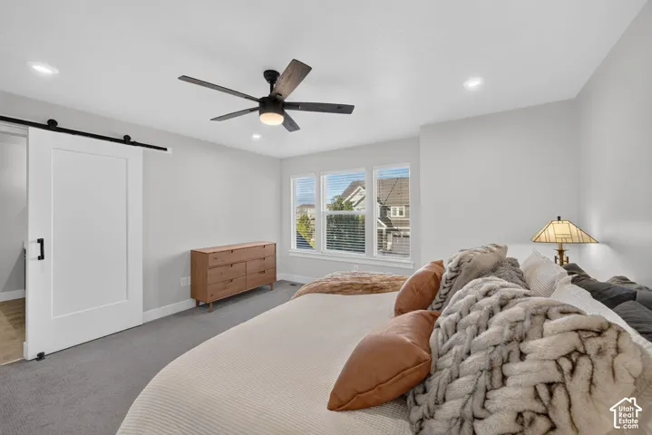 Barn door entry, recessed lighting, ceiling fan, carpet flooring, multiple windows with blinds