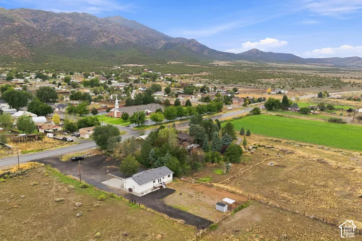 Mountain backdrop, expansive rural acreage, mature trees, paved drive, detached outbuilding