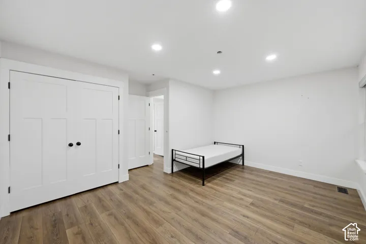 Wood-finish flooring, recessed lighting, white interior doors, and a window for natural light