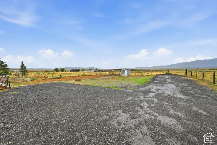 Gravel surface, white storage shed, fenced perimeter, distant mountains