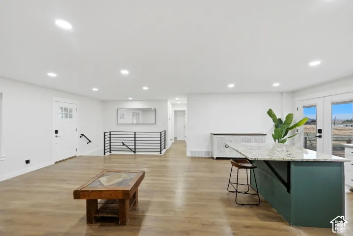 Recessed lighting illuminates wood-finish flooring