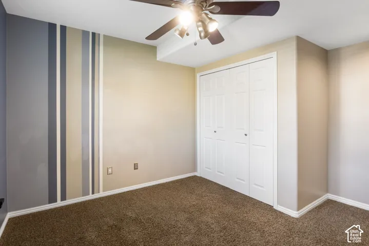 Carpeted flooring, bi-fold closet doors, ceiling fan with integrated lighting, and painted walls