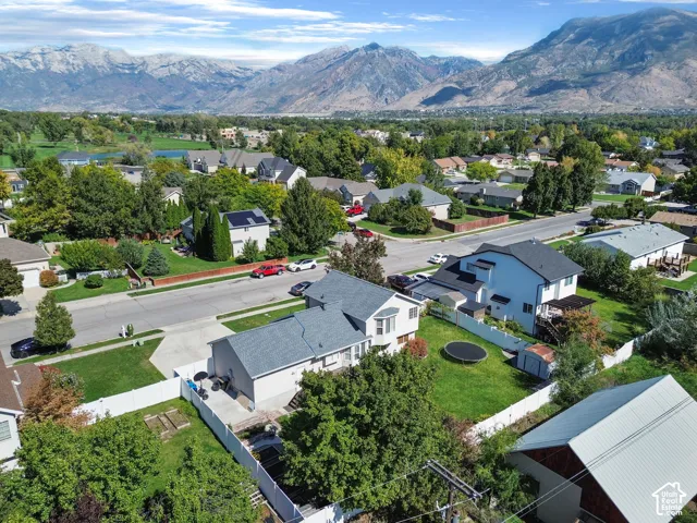 Mountain backdrop, residential neighborhood, mature trees, manicured lawns, paved streets