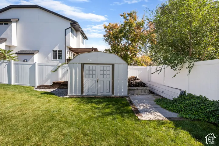 Expansive lawn area, durable vinyl fencing, dedicated storage shed, and mature perimeter trees