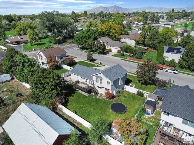 Expansive green lawn with mature trees and a multi-level deck