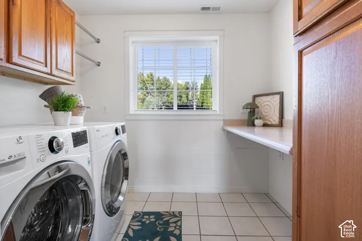 Tile flooring, white walls, wood-finish cabinetry, and a built-in counter