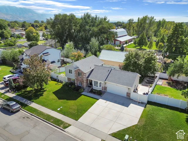 Two-story residence featuring a gray shingle roof, stone and siding exterior, an attached two-car garage, and a concrete driveway