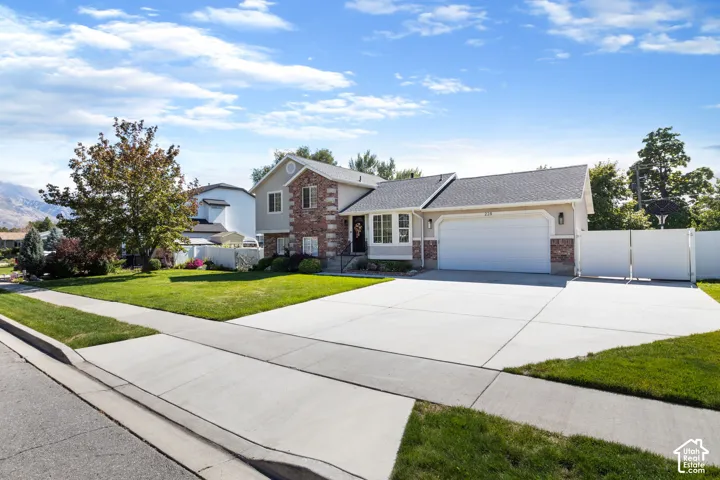 Exterior featuring a two-car garage, partial stone facade, and a concrete driveway