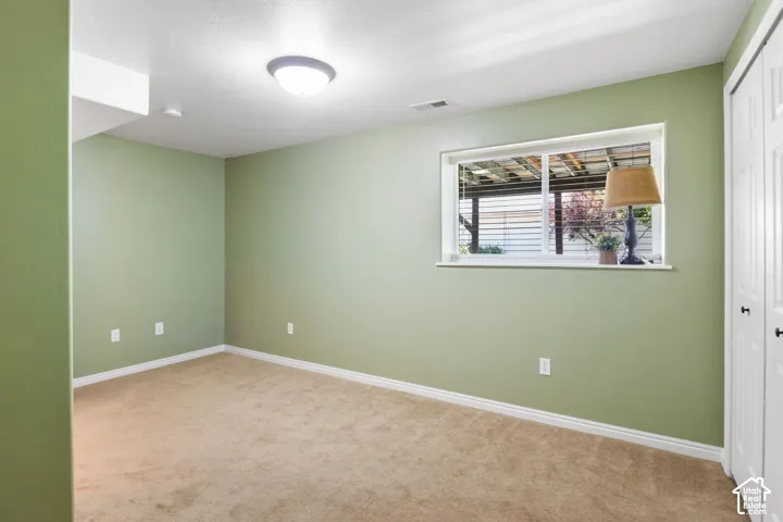 Recessed window, neutral carpeting, ceiling-mounted light fixture, white trim, and white bi-fold closet doors
