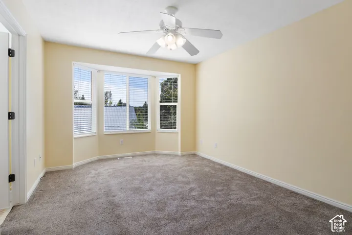 Primary Bedroom with Bay window with blinds, ceiling fan with integrated lighting, , and carpet flooring