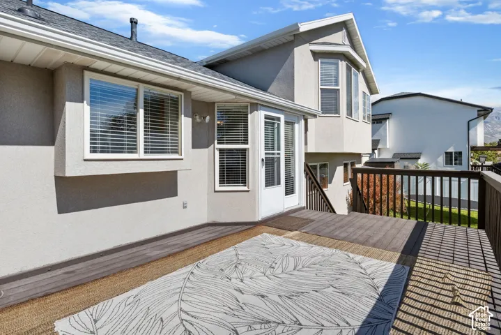 Expansive multi-level deck, stucco exterior, multiple windows, and a bay window feature