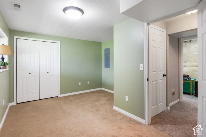 Wall-to-wall carpeting with light green wall paint and white trim