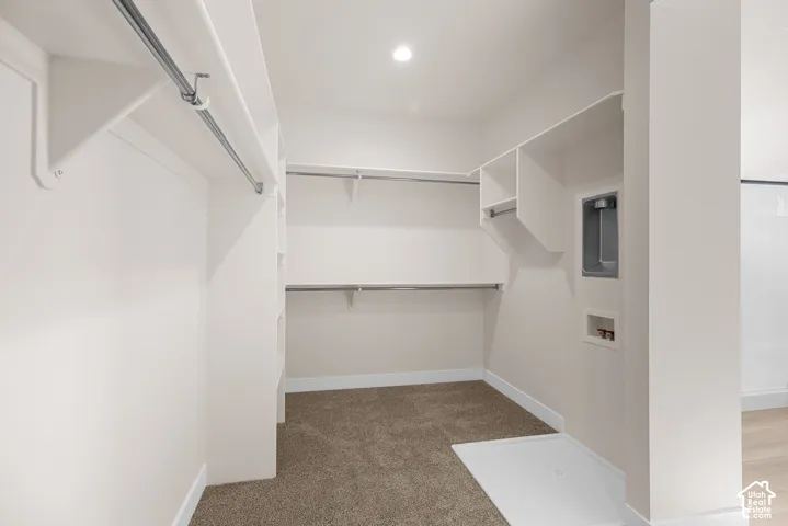Integrated laundry hookups, built-in shelving, hanging rods, recessed lighting, and carpet flooring