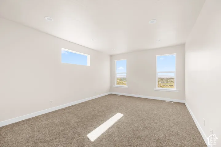 Recessed lighting, light-colored walls, carpeted flooring, and multiple windows