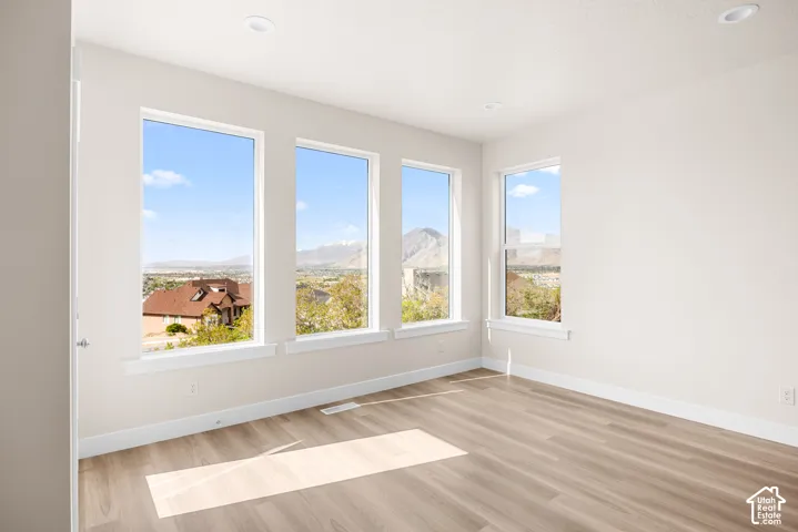 Light-filled interior featuring multiple windows, wood-finish flooring, recessed lighting, and white trim