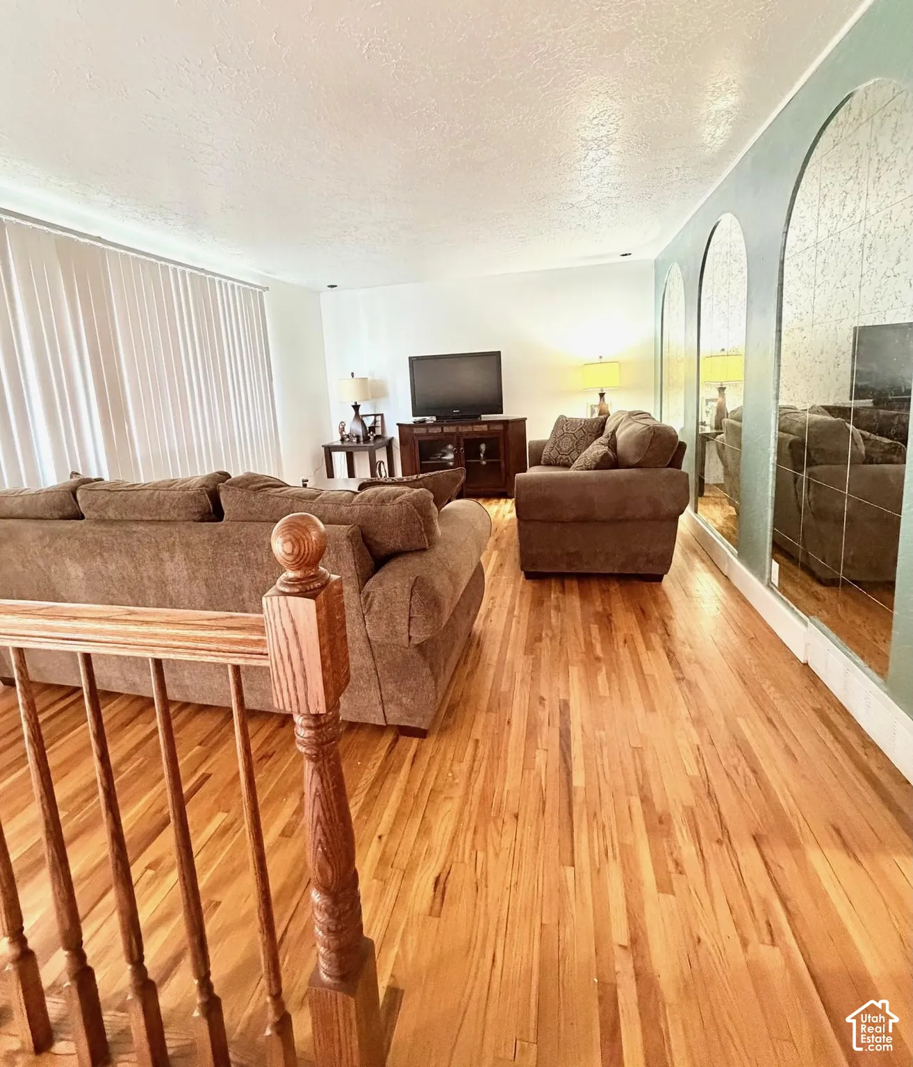 Vinyl flooring throughout, featuring a natural wood finish and arched wall mirrors