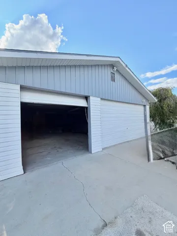 Two garage bays with roll-up doors and concrete approach
