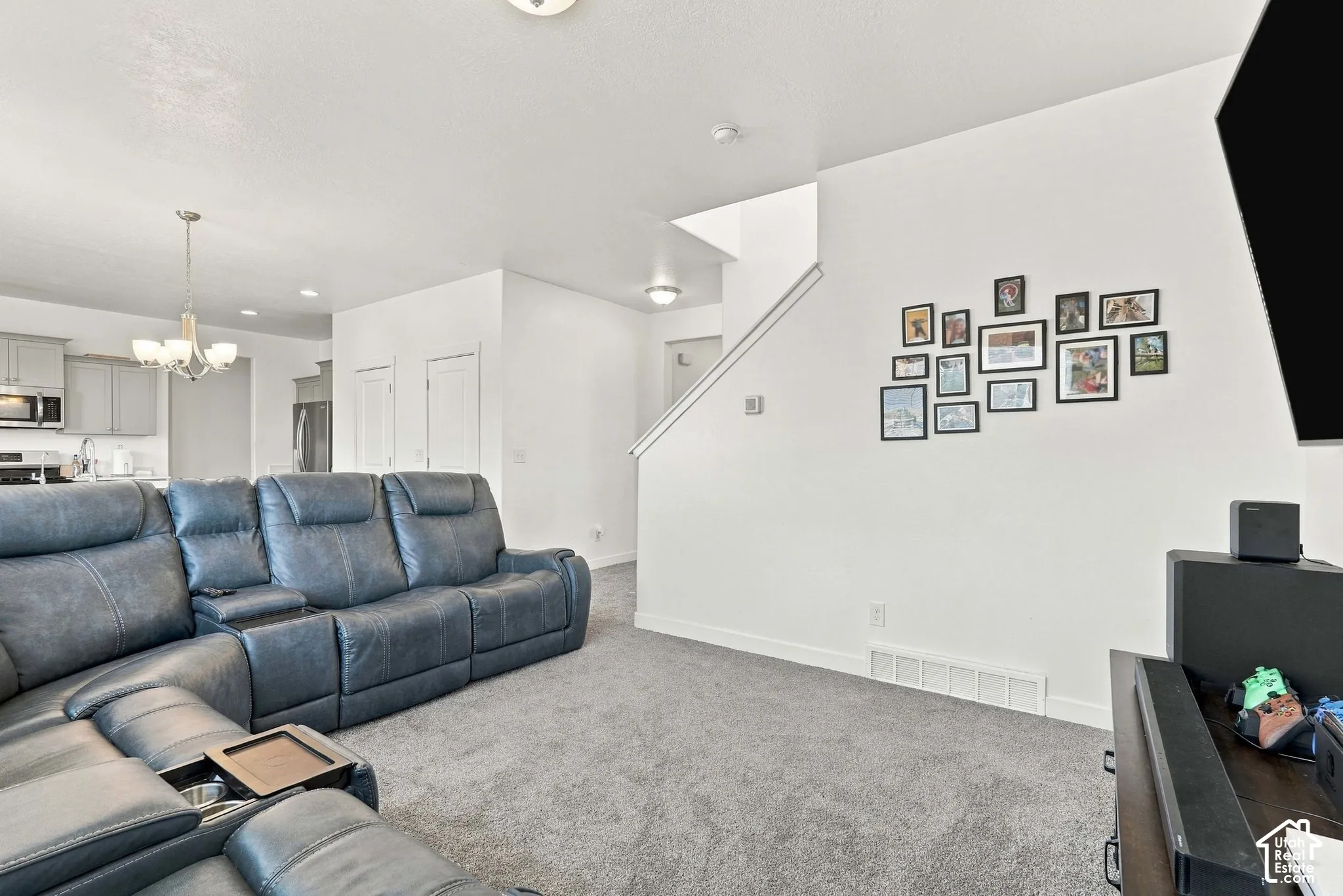 Open-concept living area with light gray carpeting and white walls