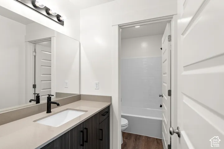 Bathroom vanity with an integrated rectangular sink, matte black faucet, and wood-finish cabinetry