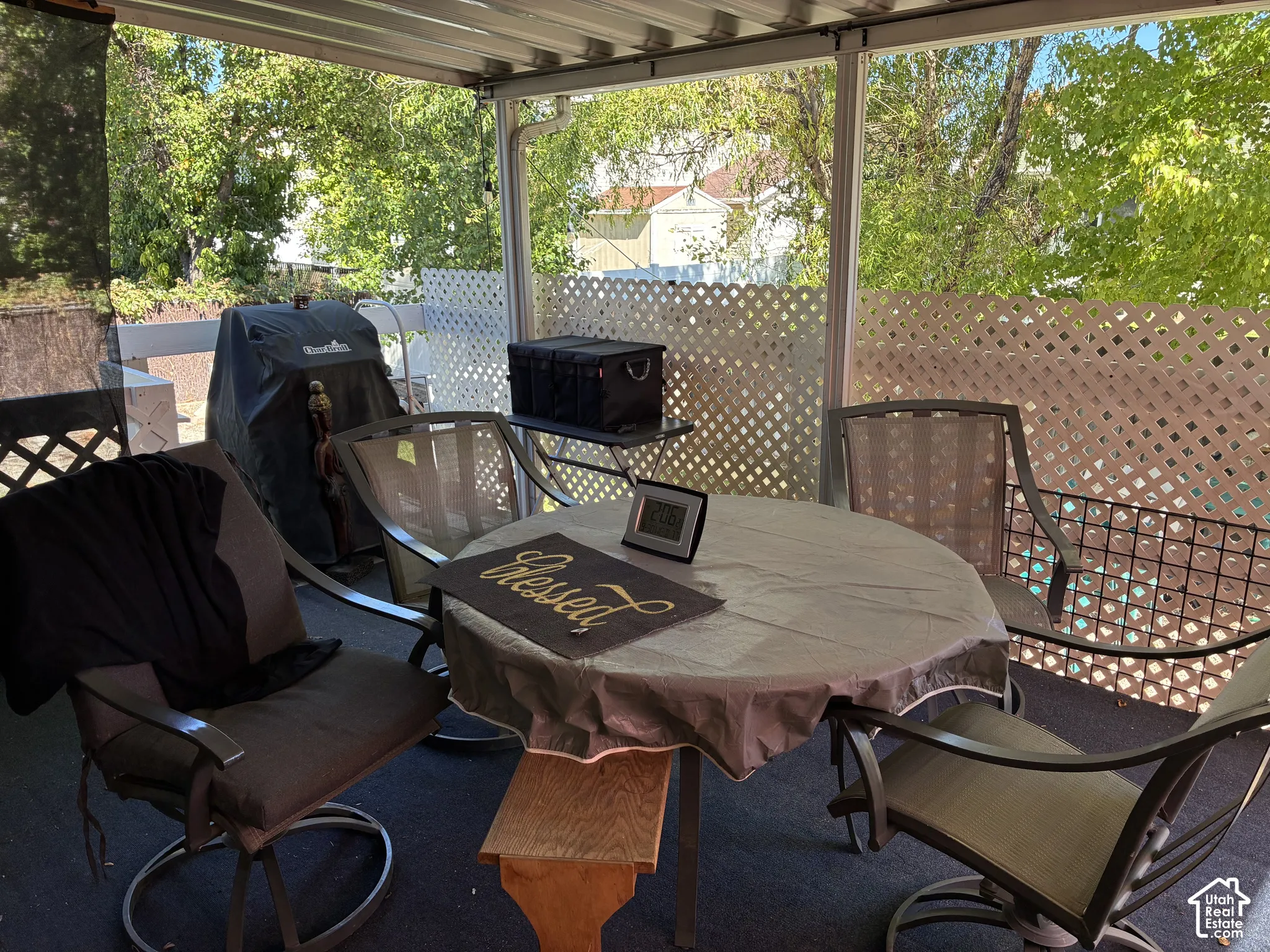 Covered patio featuring a metal roof structure and lattice fencing