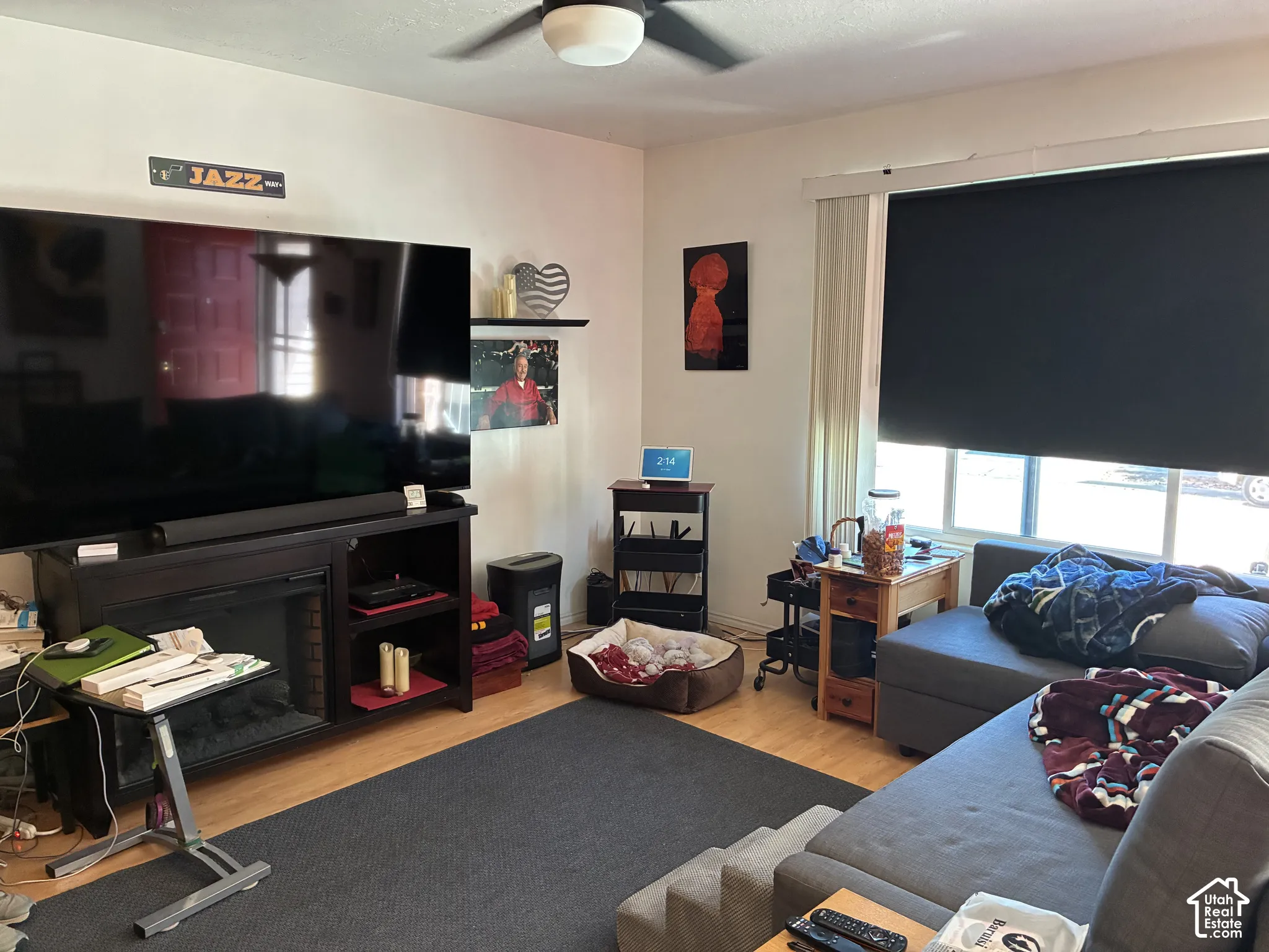 Wood-finish flooring, ceiling fan, and window with roller shade
