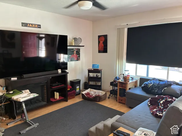 Wood-finish flooring, ceiling fan, and window with roller shade