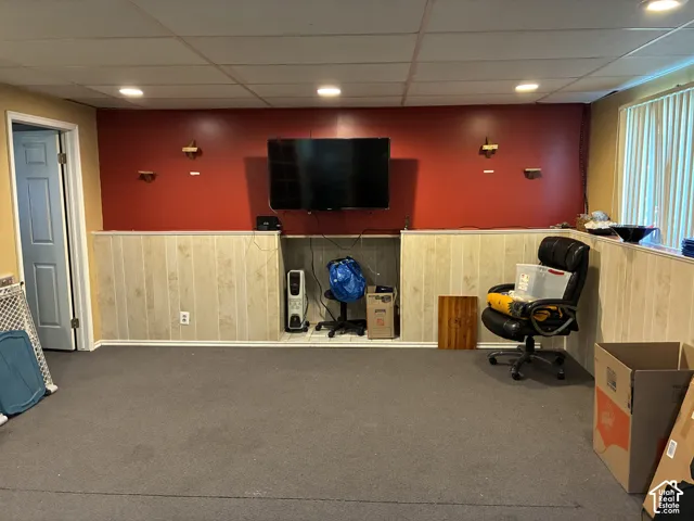 Recessed lighting, drop ceiling, wainscoting, built-in media niche, and light-filtering window treatments