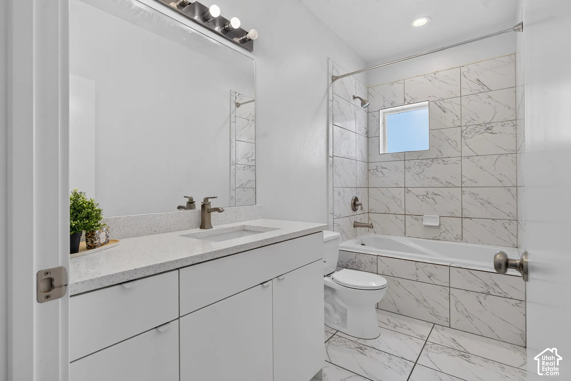 Vanity with a light-colored countertop, undermount sink, and brushed nickel faucet