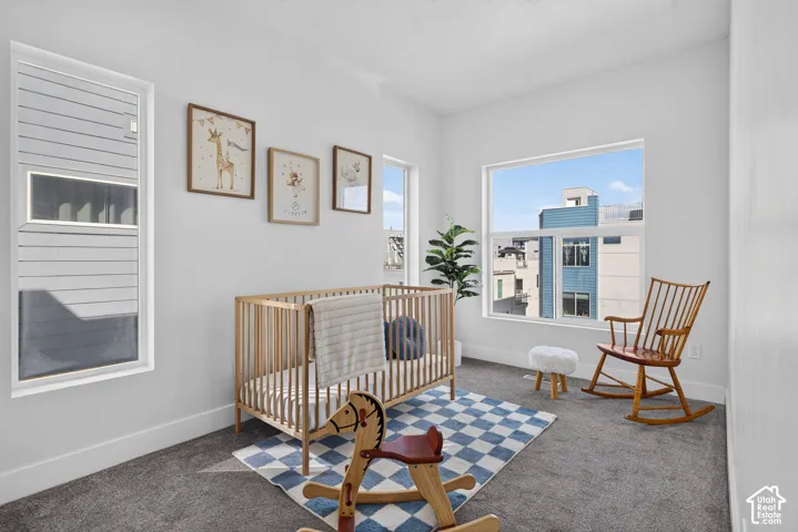 Plush gray carpeting, large picture windows, and bright white walls create an inviting atmosphere